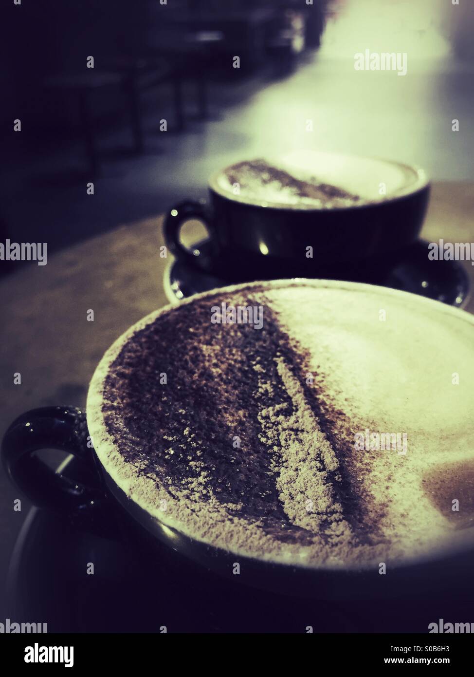Two cappuccino coffees on table in cafe Stock Photo