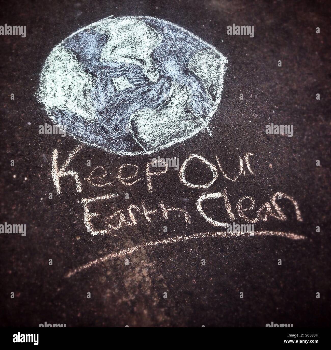 Keep our Earth clean. A message from Emma, my ten year old daughter. A child's chalk drawing on asphalt. Stock Photo