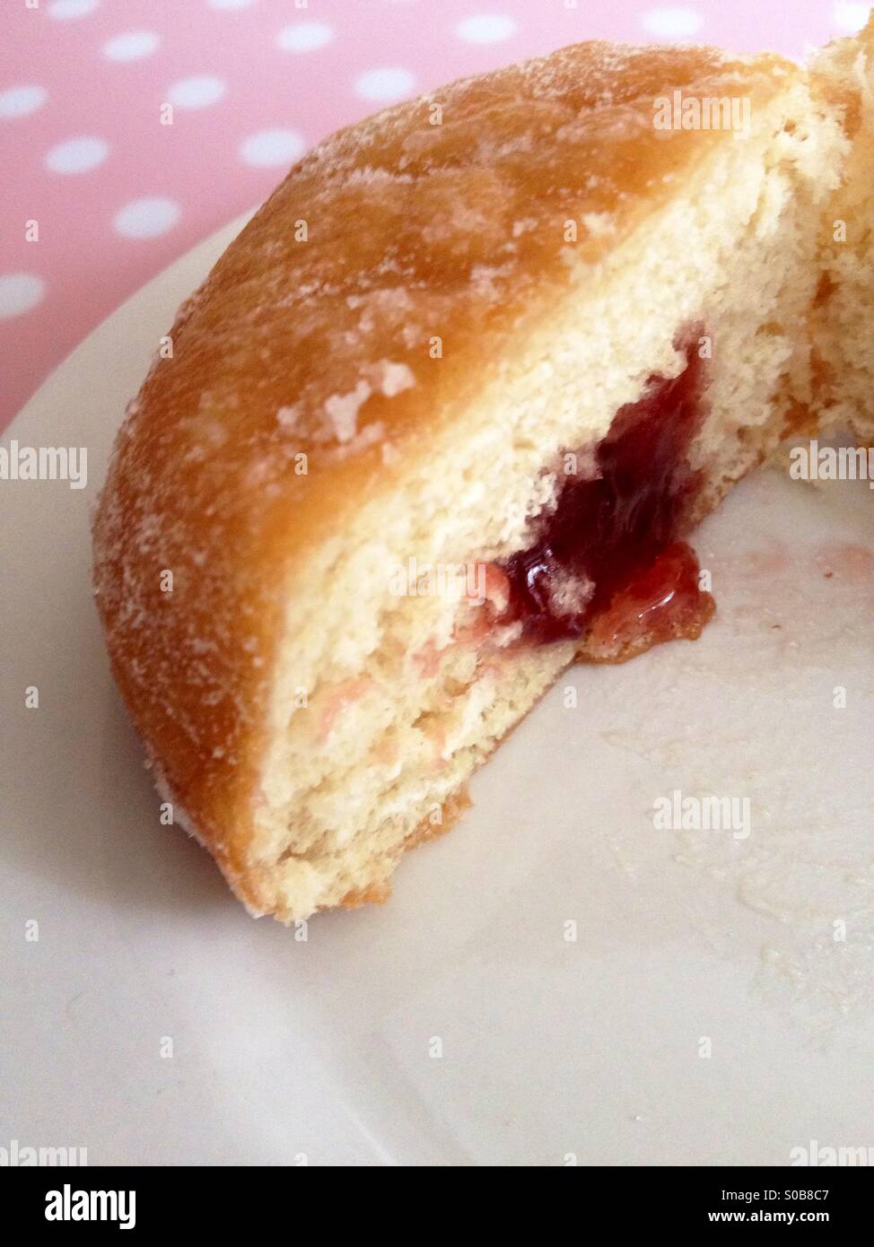 Jam filled doughnut on a white plate Stock Photo