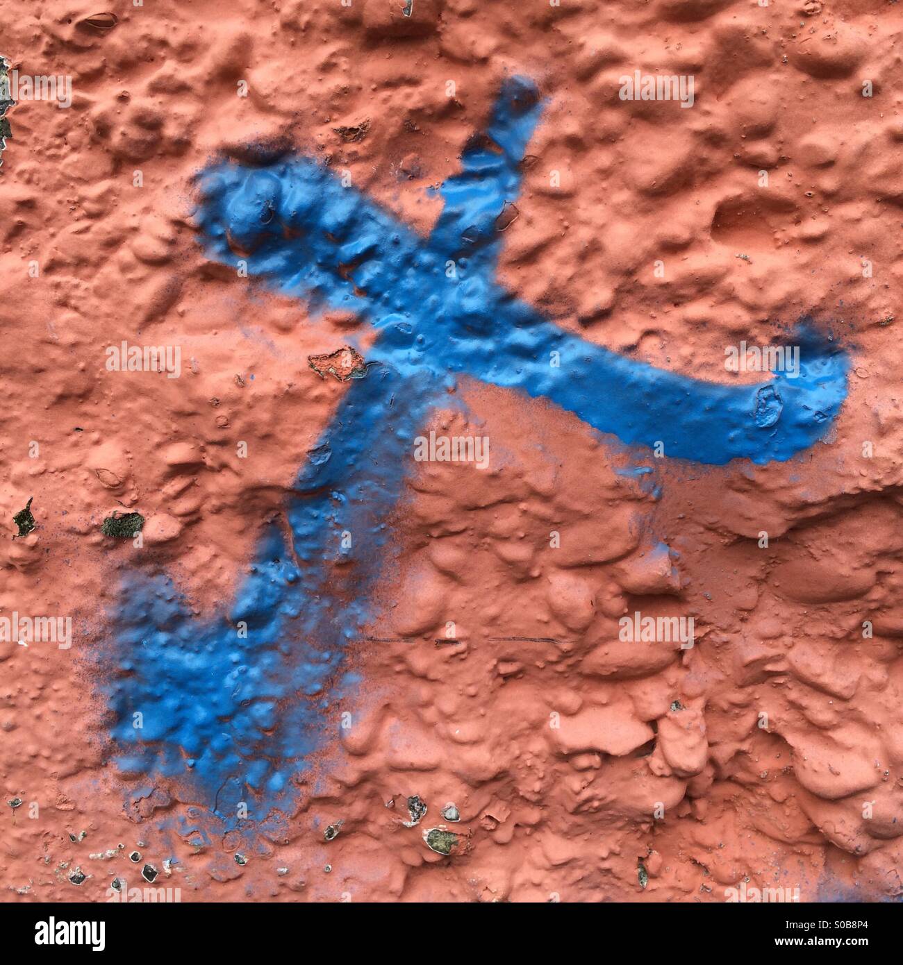 Blue X painted on rough orange surface - Smartphone Captured Stock Image