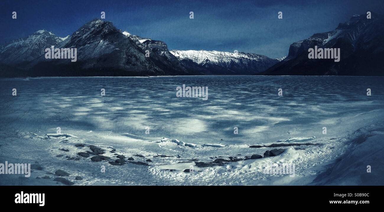 Thinning ice on frozen Lake Minnewanke, looking towards Devil's Gap, in Banff national park, Alberta, Canada. - Smartphone Captured Stock Image