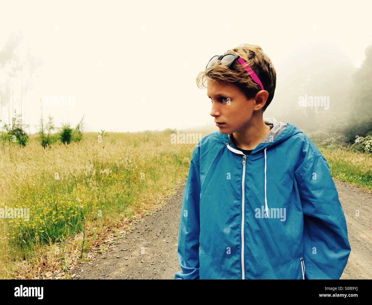 A boy walking on a country track on a foggy day - Smartphone Captured Stock Image