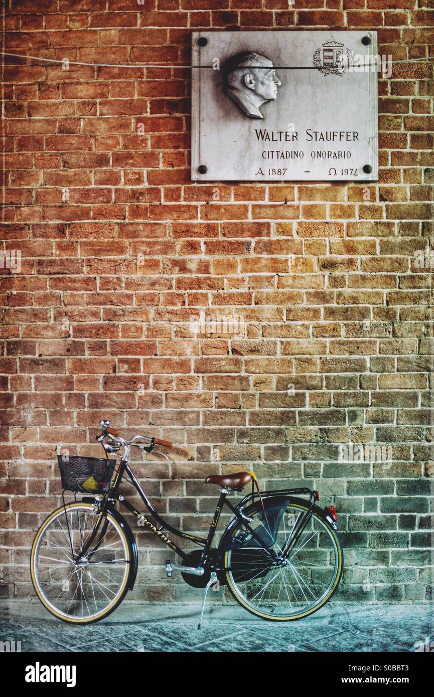 Bike under statue. Cremona Italy Stock Photo - Alamy