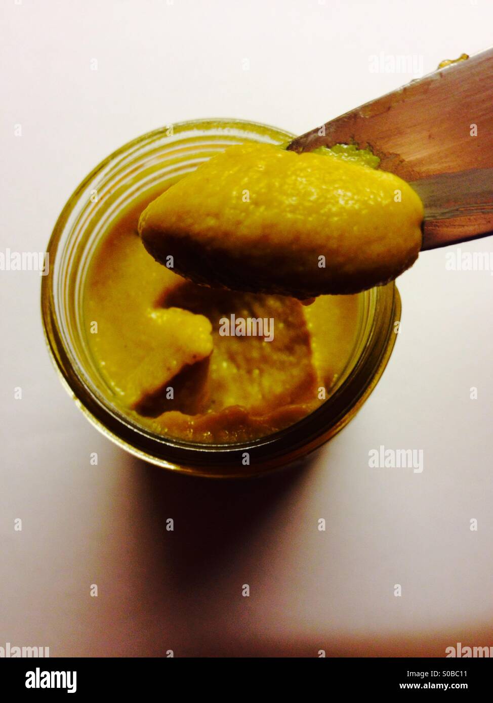 New jar of mustard being used for the first time - Smartphone Captured Stock Image