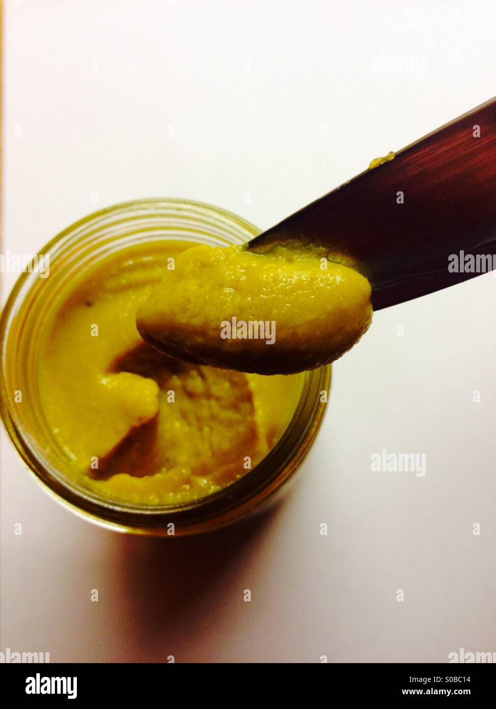 New jar of mustard being used for the first time - Smartphone Captured Stock Image