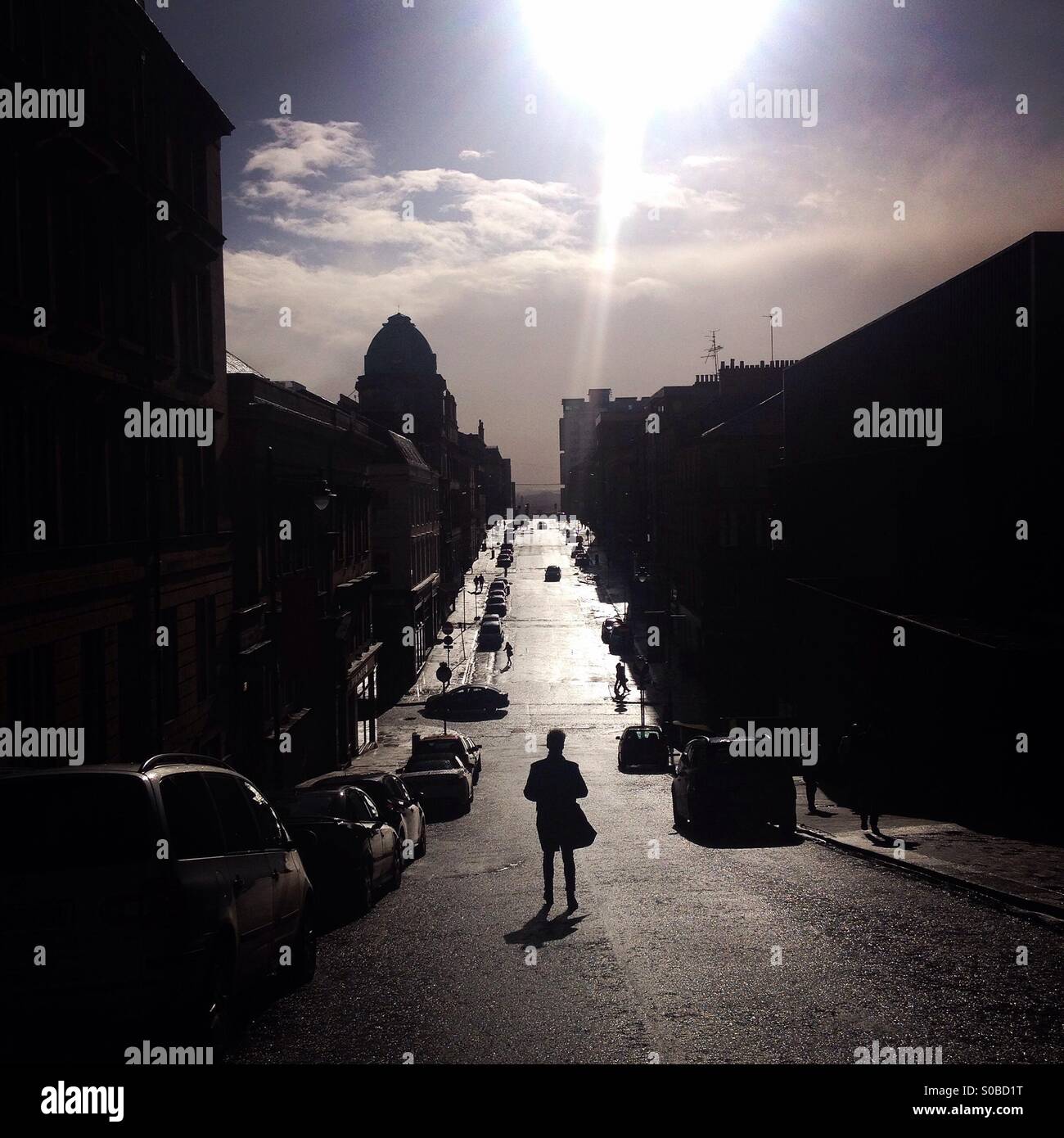 Man walking in sunlit street, Glasgow, Scotland Stock Photo