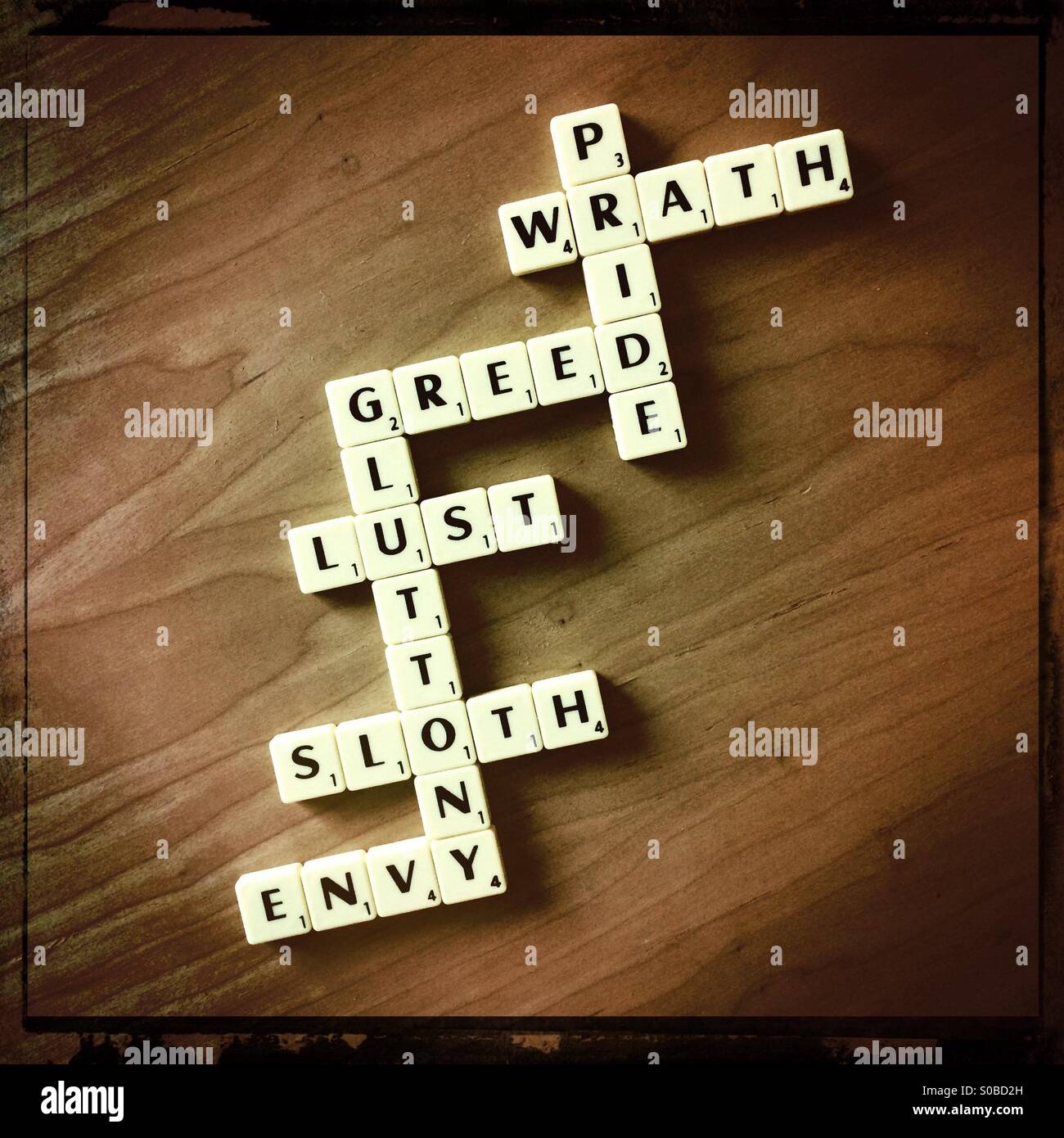 7 Deadly Sins spelled out in scrabble tiles Stock Photo
