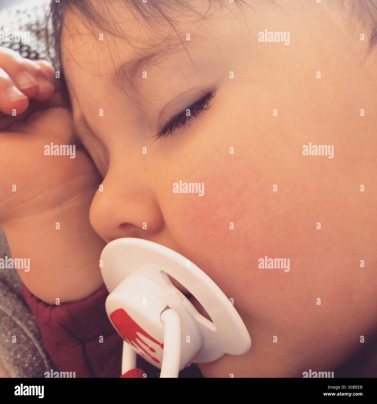 Young baby sleeping with soother Stock Photo
