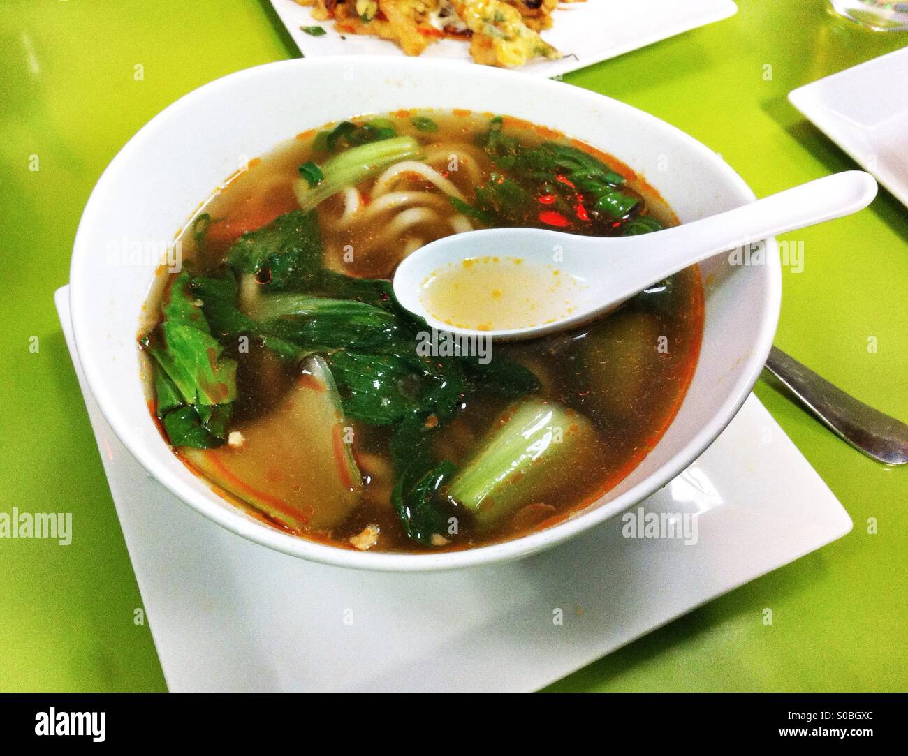 white bowl of udon noodles with vegetables Stock Photo