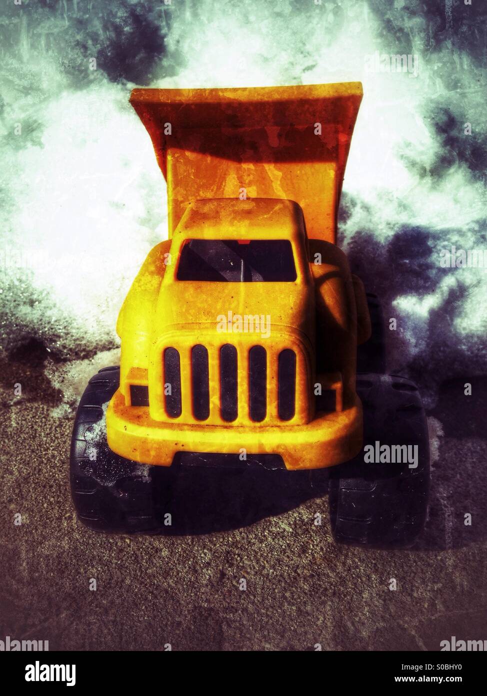 A toy dump truck dumping snow (grunge). - Smartphone Captured Stock Image