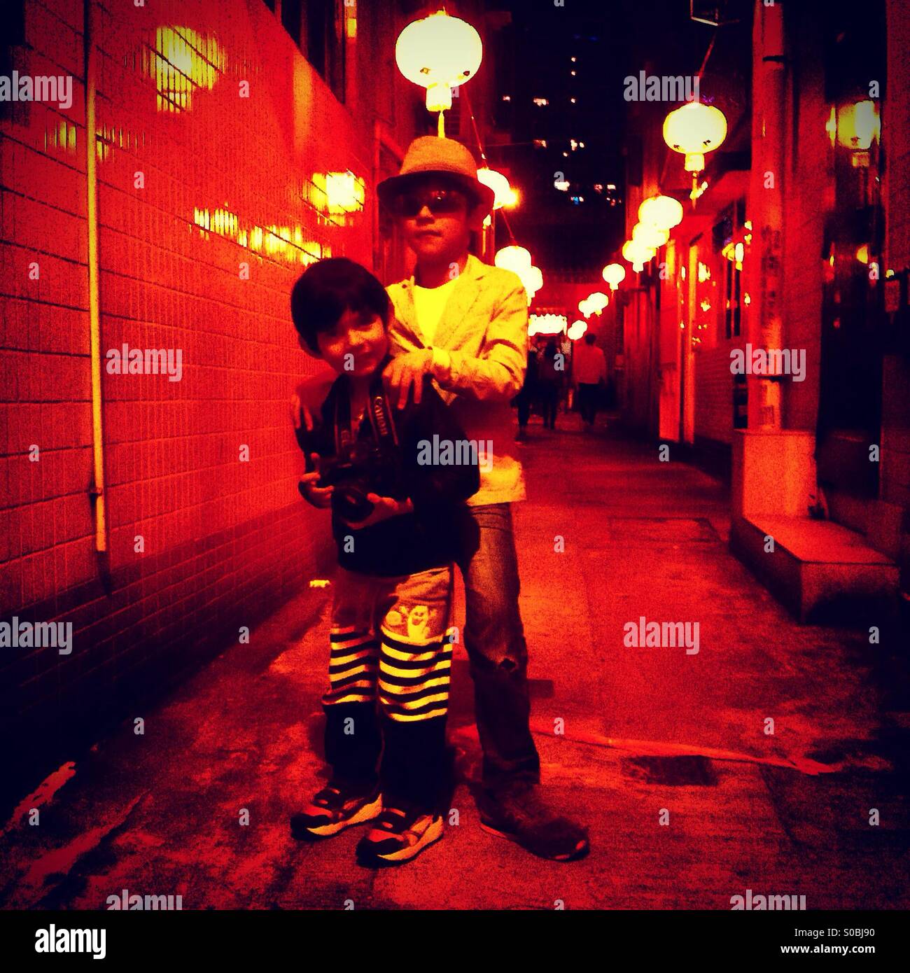 Brothers in style. Small street with red lanterns - Smartphone Captured Stock Image