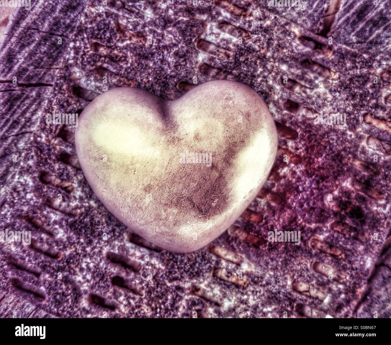 Ceramic heart sitting on a metal background - Smartphone Captured Stock Image
