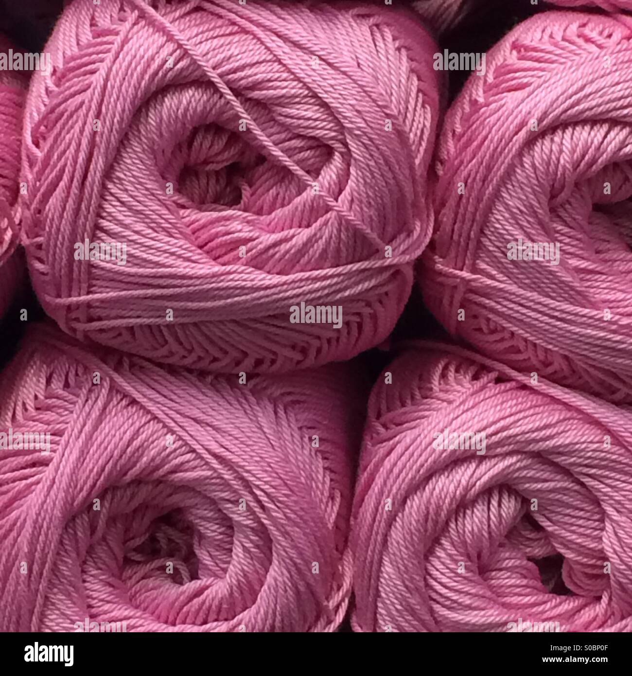 Balls of wool stacked on shelf Stock Photo