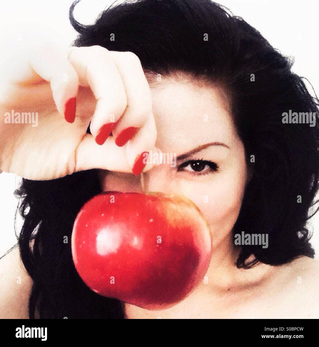 Young woman holding a red apple in front of her face Stock Photo Alamy