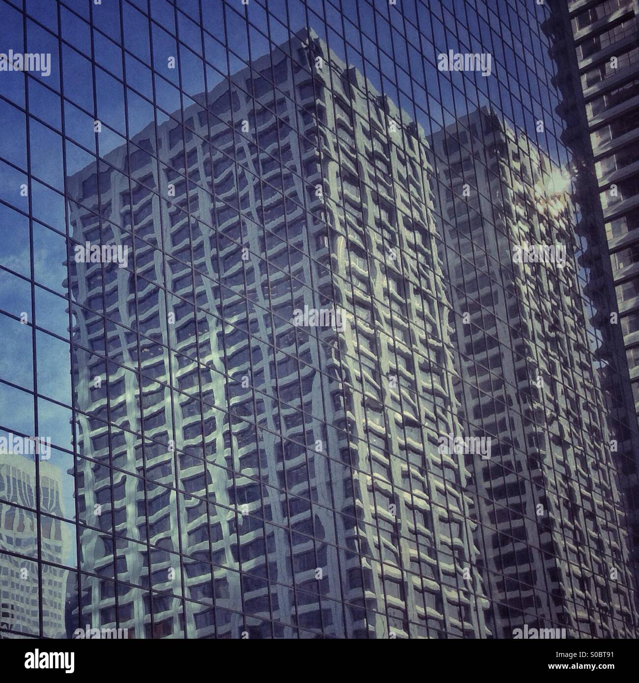 City buildings reflected in another building. Stock Photo