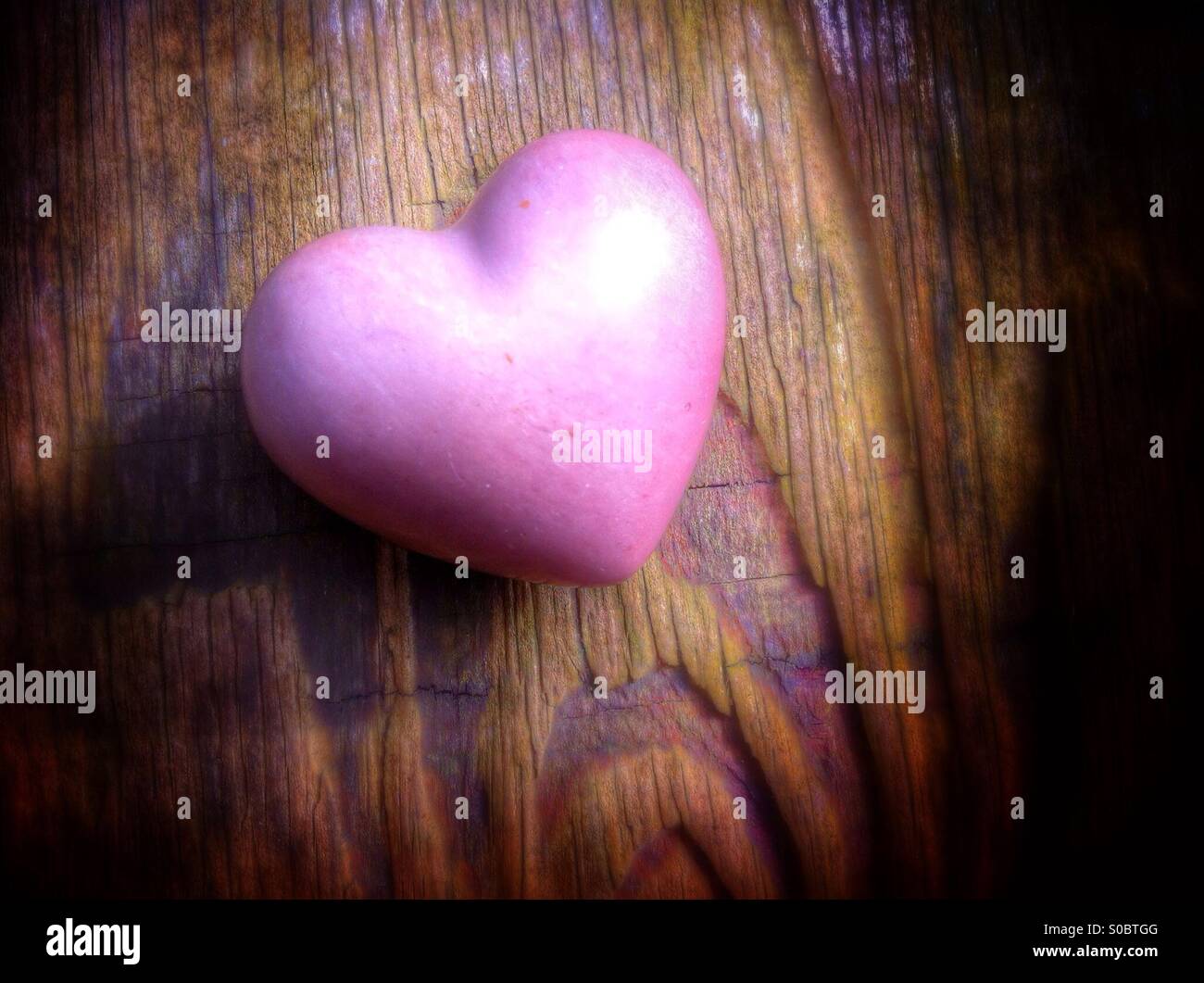 Ceramic heart sitting on old weathered and deeply grained wood - Smartphone Captured Stock Image