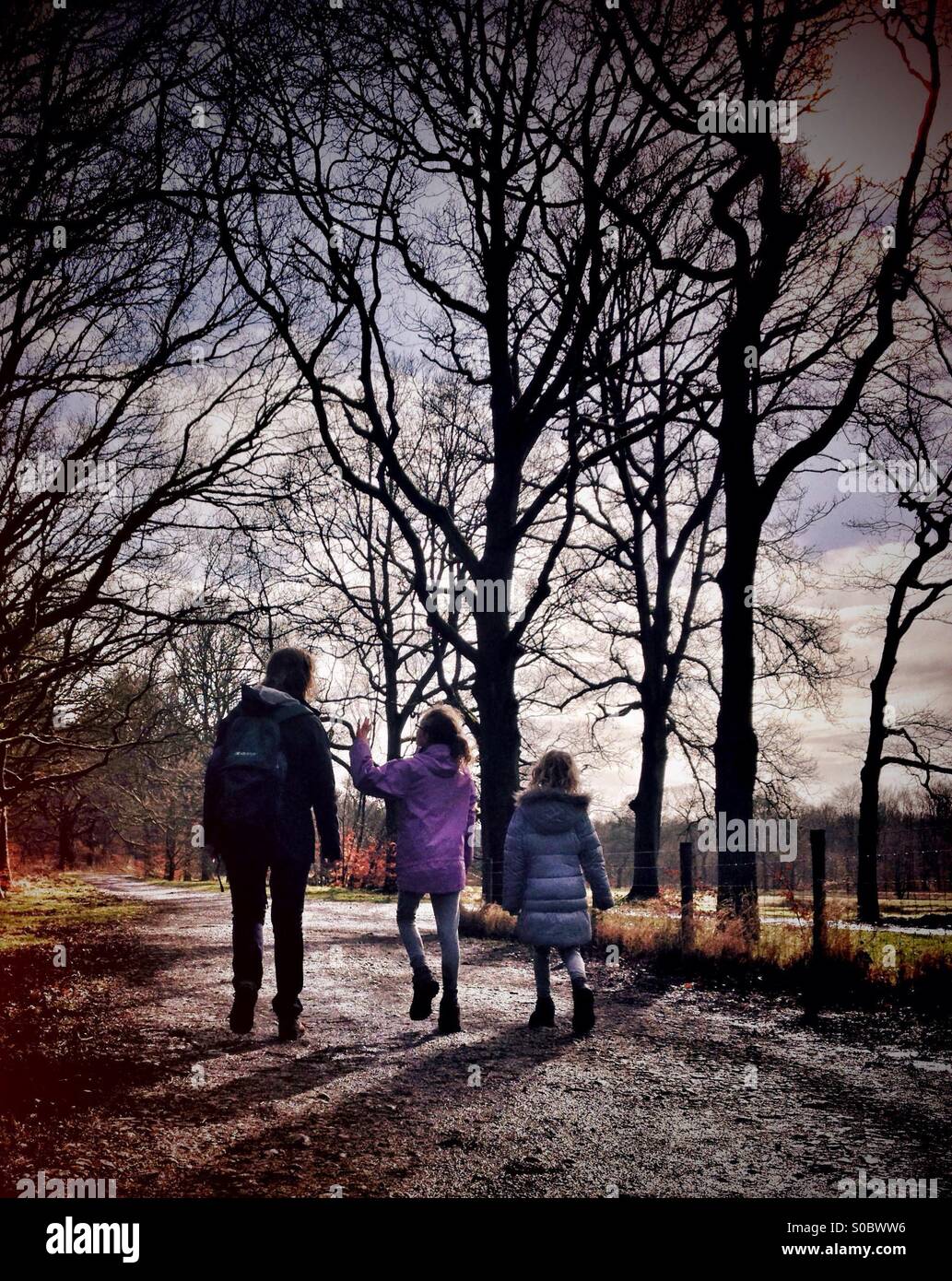 Mother and daughters walking along country lane Stock Photo - Alamy