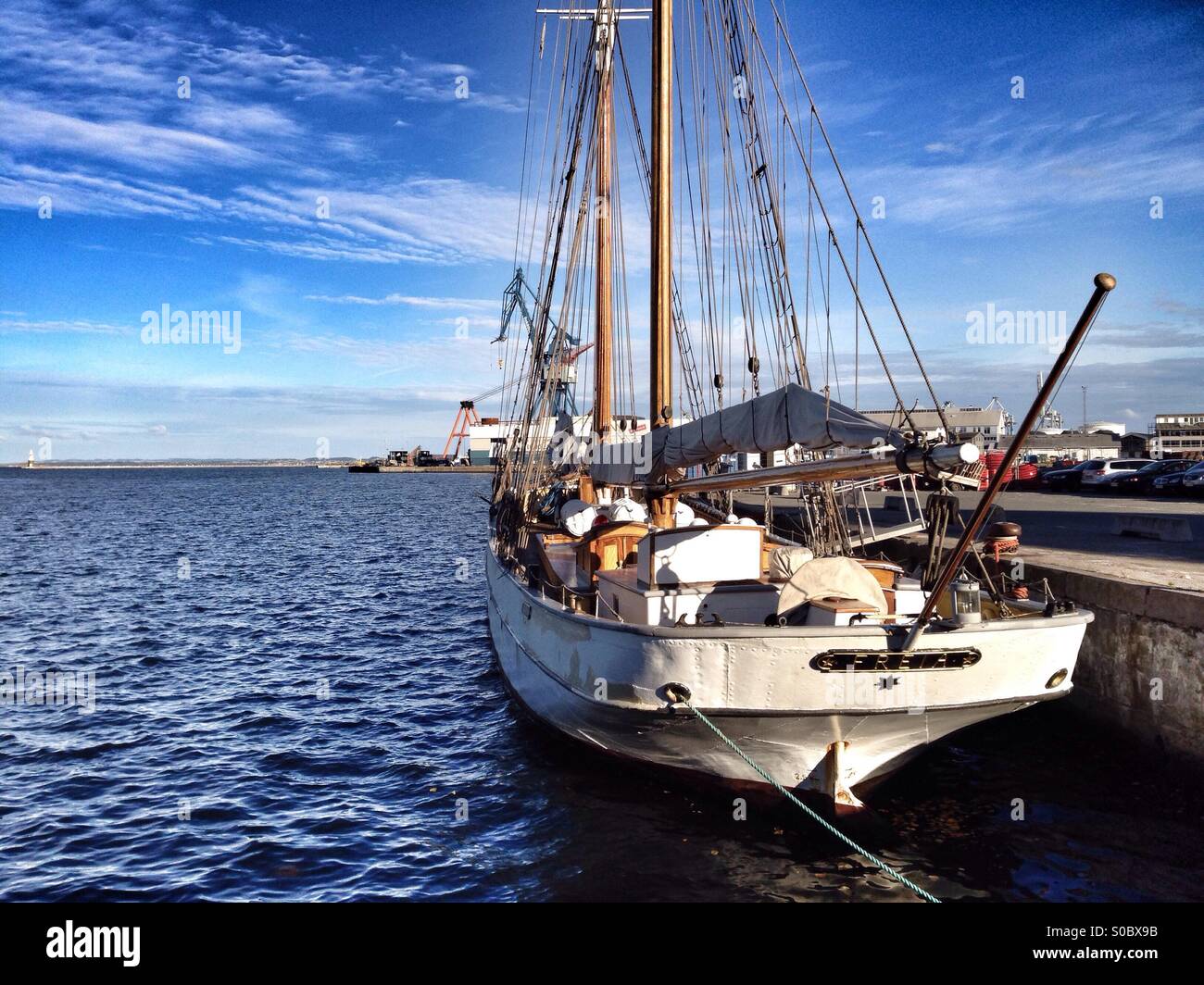 Sail boat in the the sea in a spring day, blue sky with a few white clouds, blue water - Smartphone Captured Stock Image