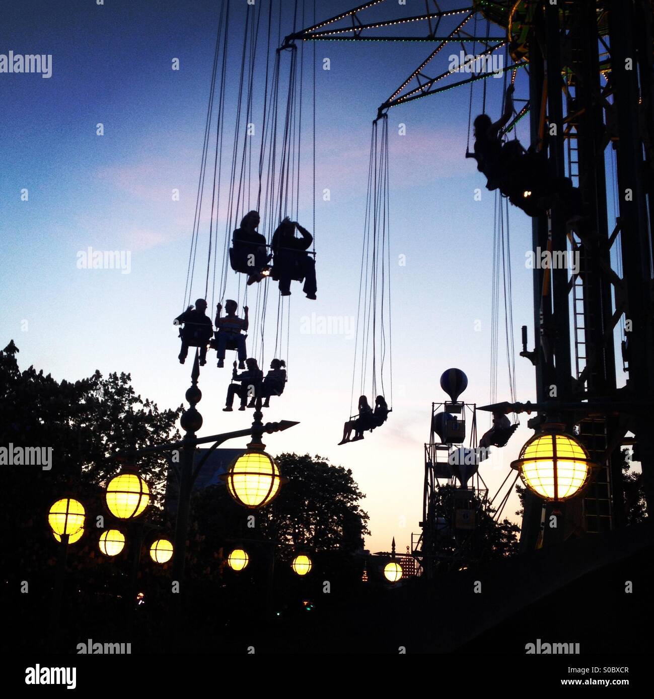 People on the world's highest carousel in the Tivoli Gardens in Copenhagen Denmark at sunset - Smartphone Captured Stock Image