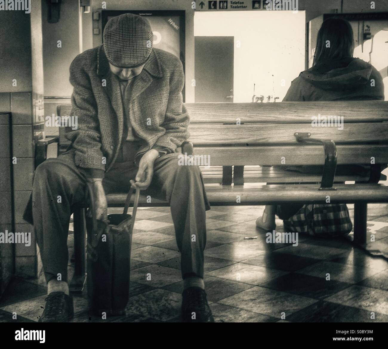 Old man at trainstation Stock Photo