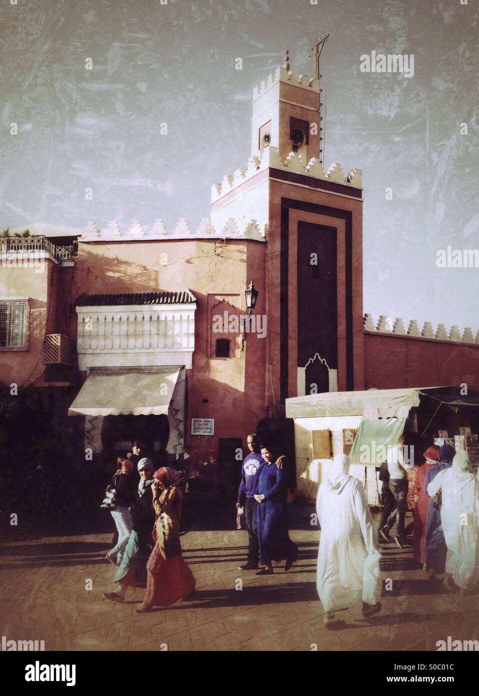 People strolling past a mosque. Jemaa El Fna, Marrakech, Morocco. Stock Photo