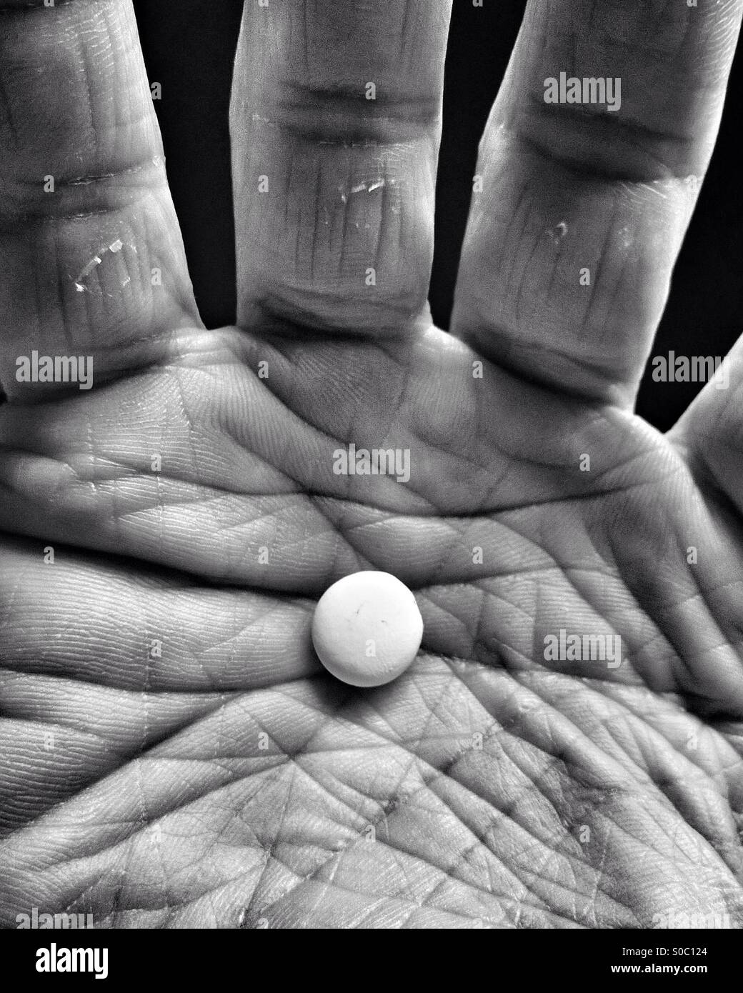 White pill in palm of hand. Stock Photo