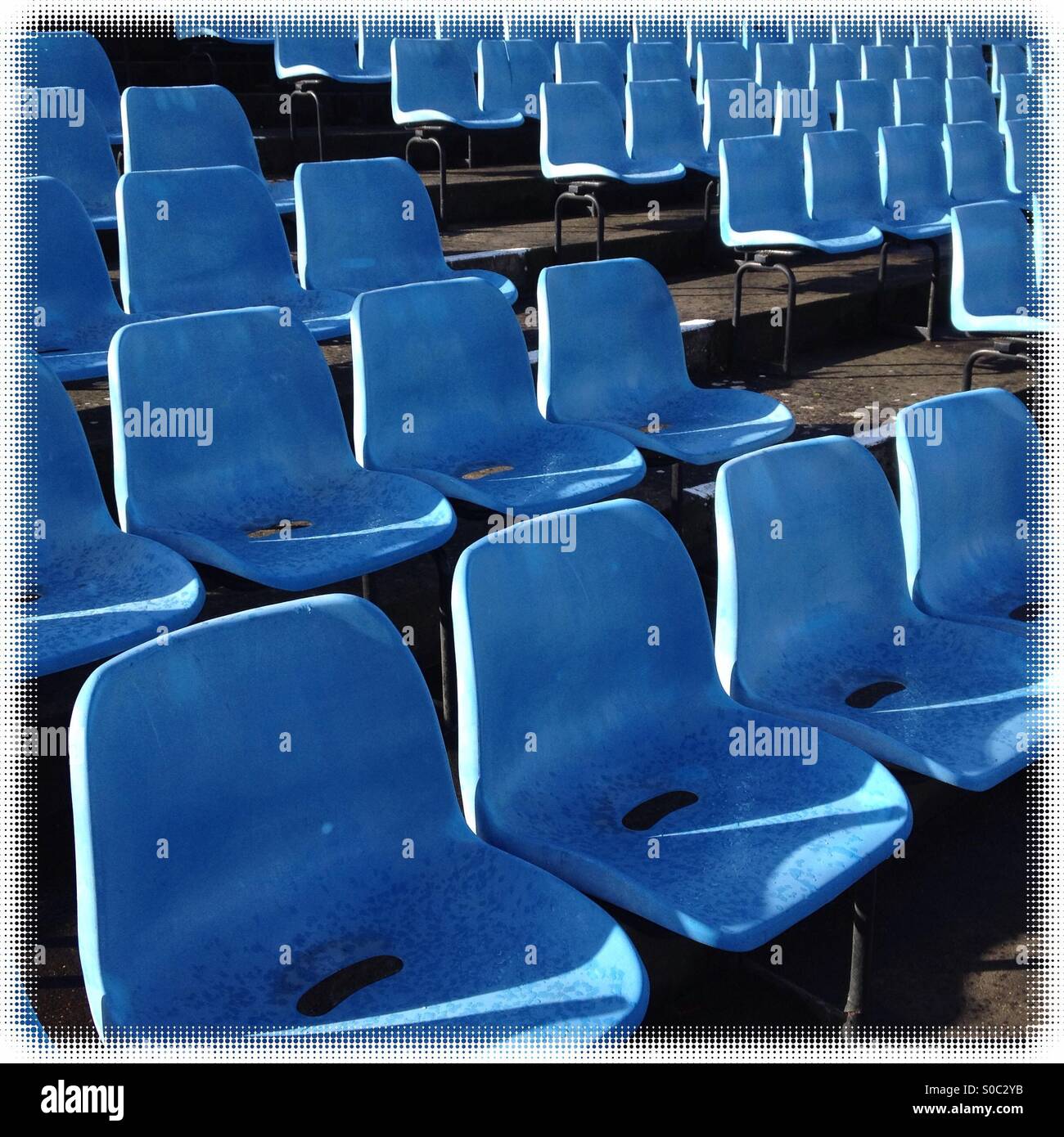 Blue is the colour; rows of seating at the local county cricket ground. - Smartphone Captured Stock Image