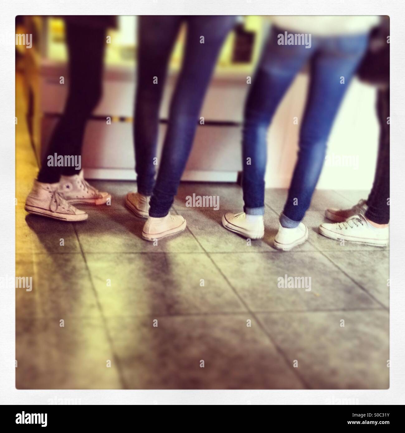 Four girls wear skinny jeans and converse at a Stockholm cafe Stock Photo -  Alamy
