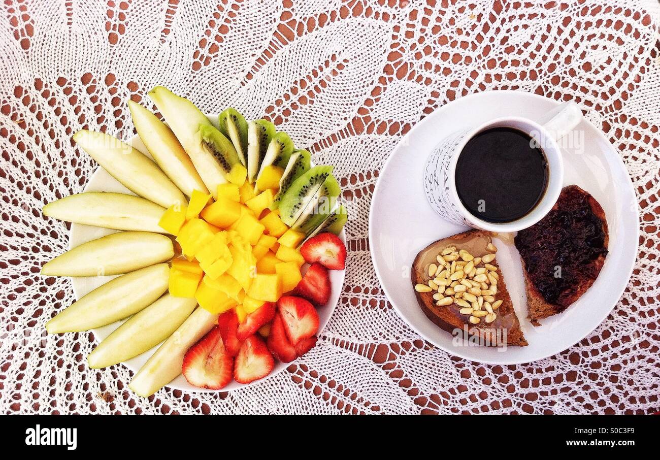 Breakfast on lace tablecloth with cut fruits and coffee - Smartphone Captured Stock Image