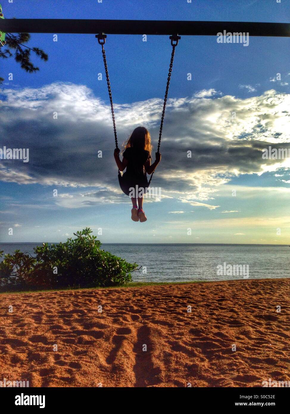 Young girl on a swing at the beach. Stock Photo