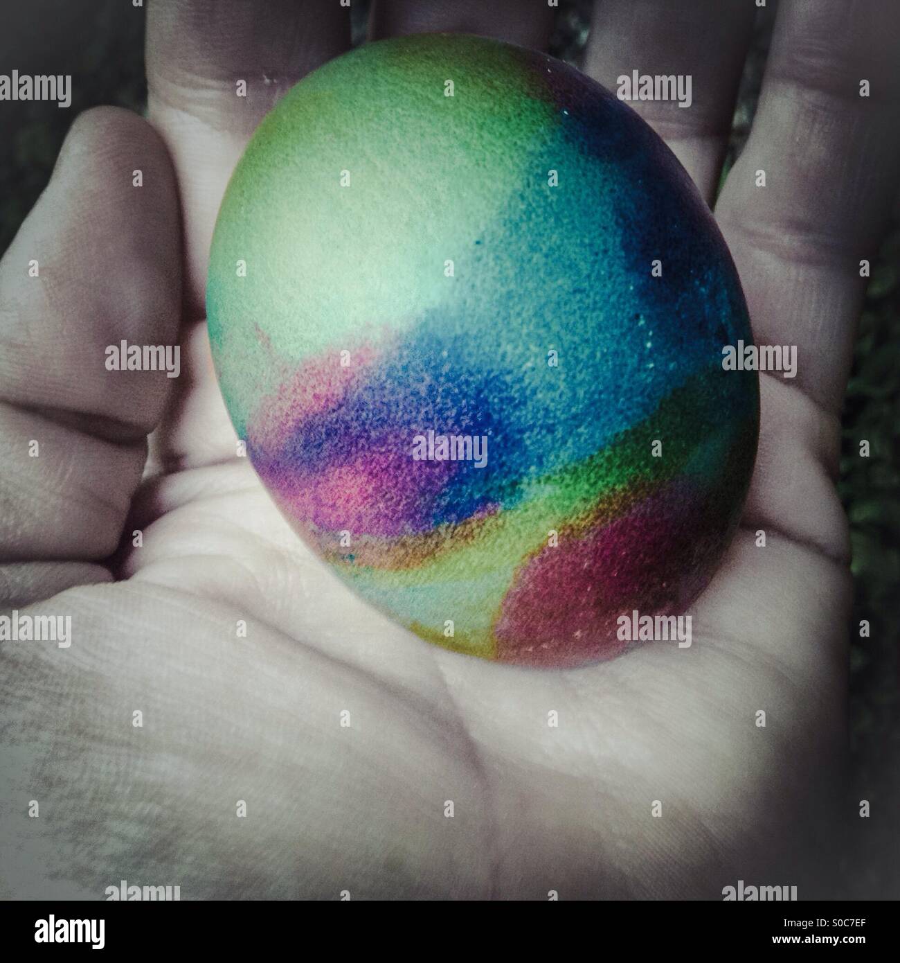 Hand holding a colorful easter egg - Smartphone Captured Stock Image