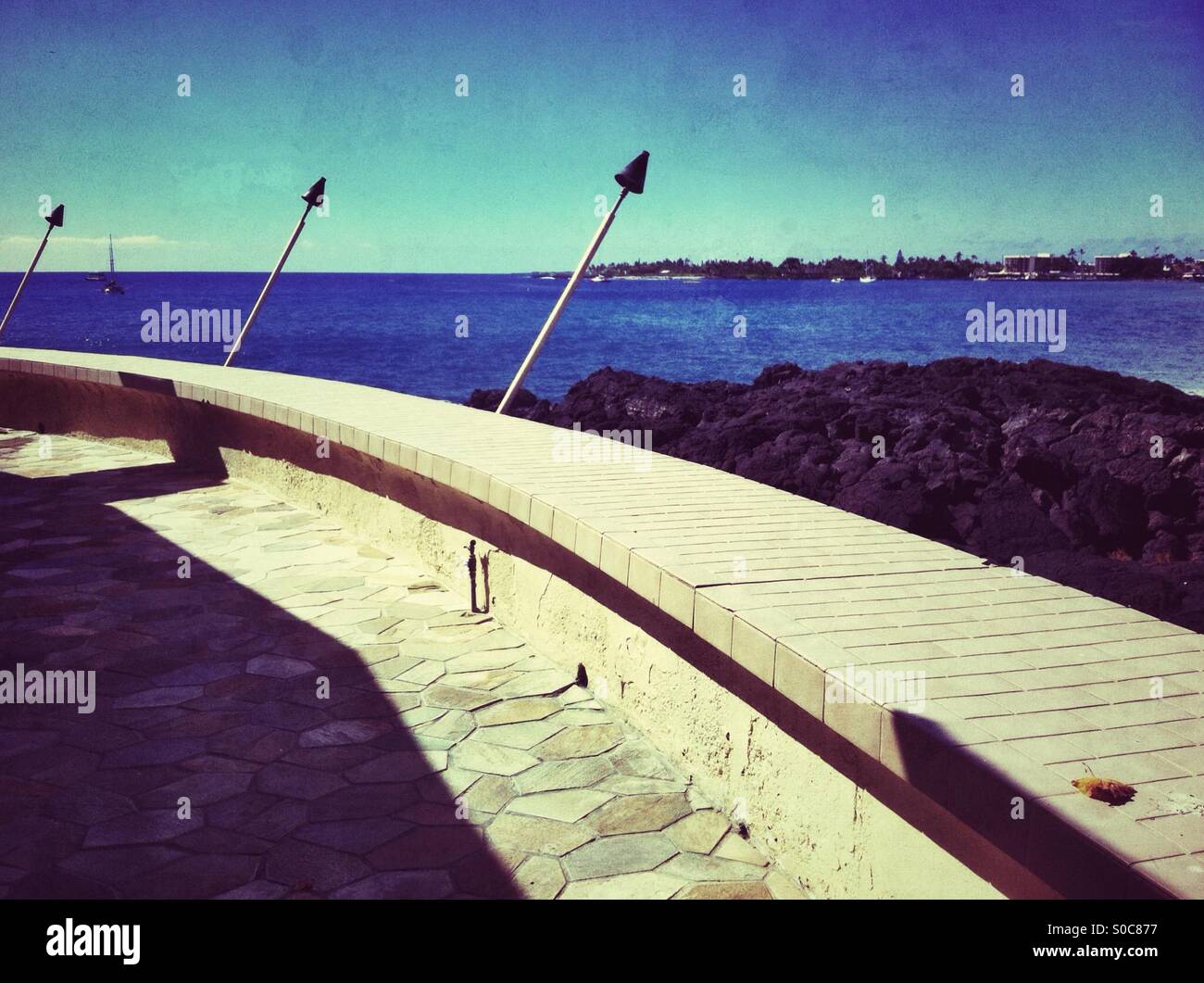 Sunlit terrace with fire torches in Kona, hawaii - Smartphone Captured Stock Image