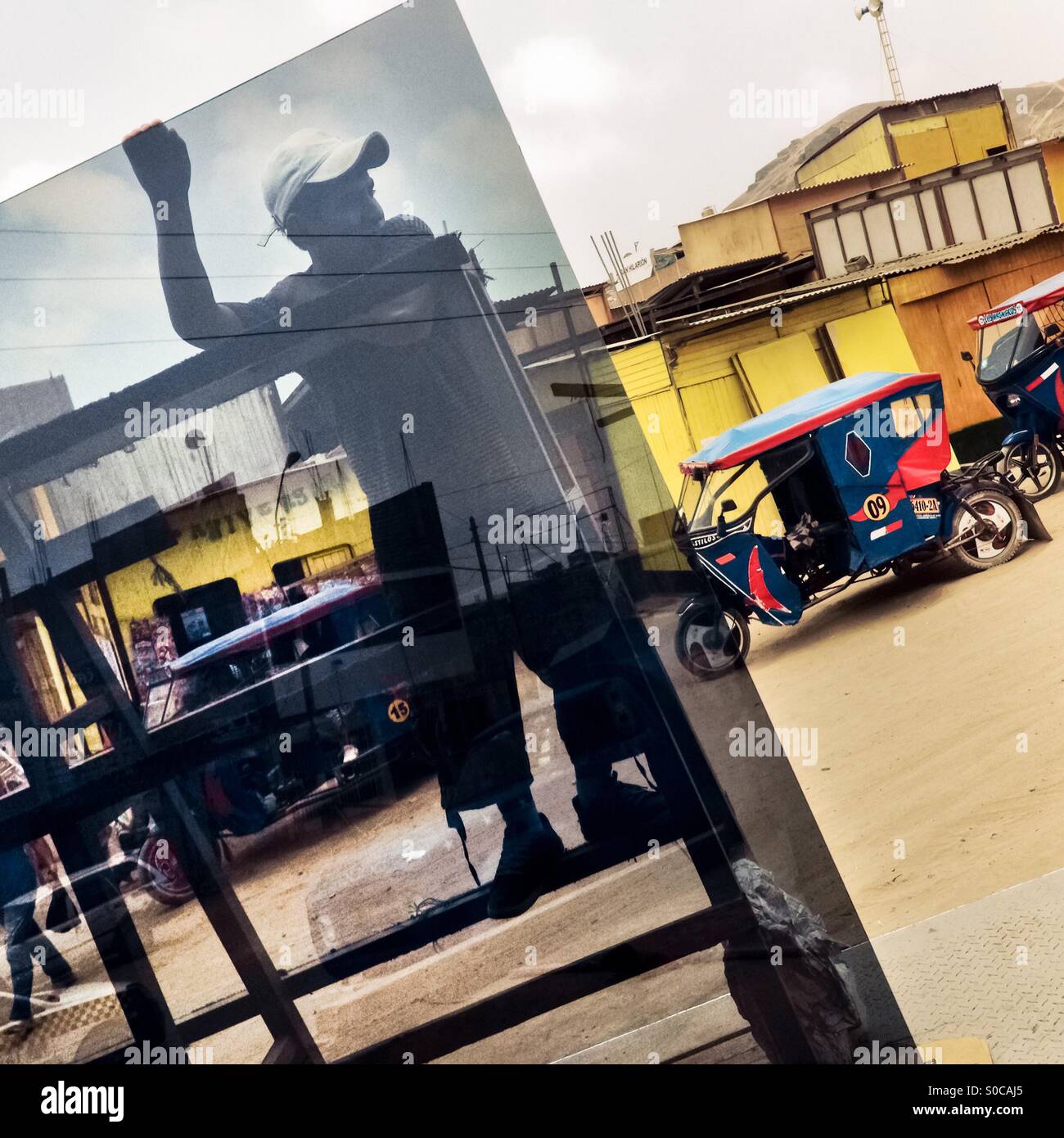 A Peruvian worker unloads a large window glass from a truck on the street of Pachacútec, a desert shantytown in Lima, Peru, 20 January 2015. Stock Photo