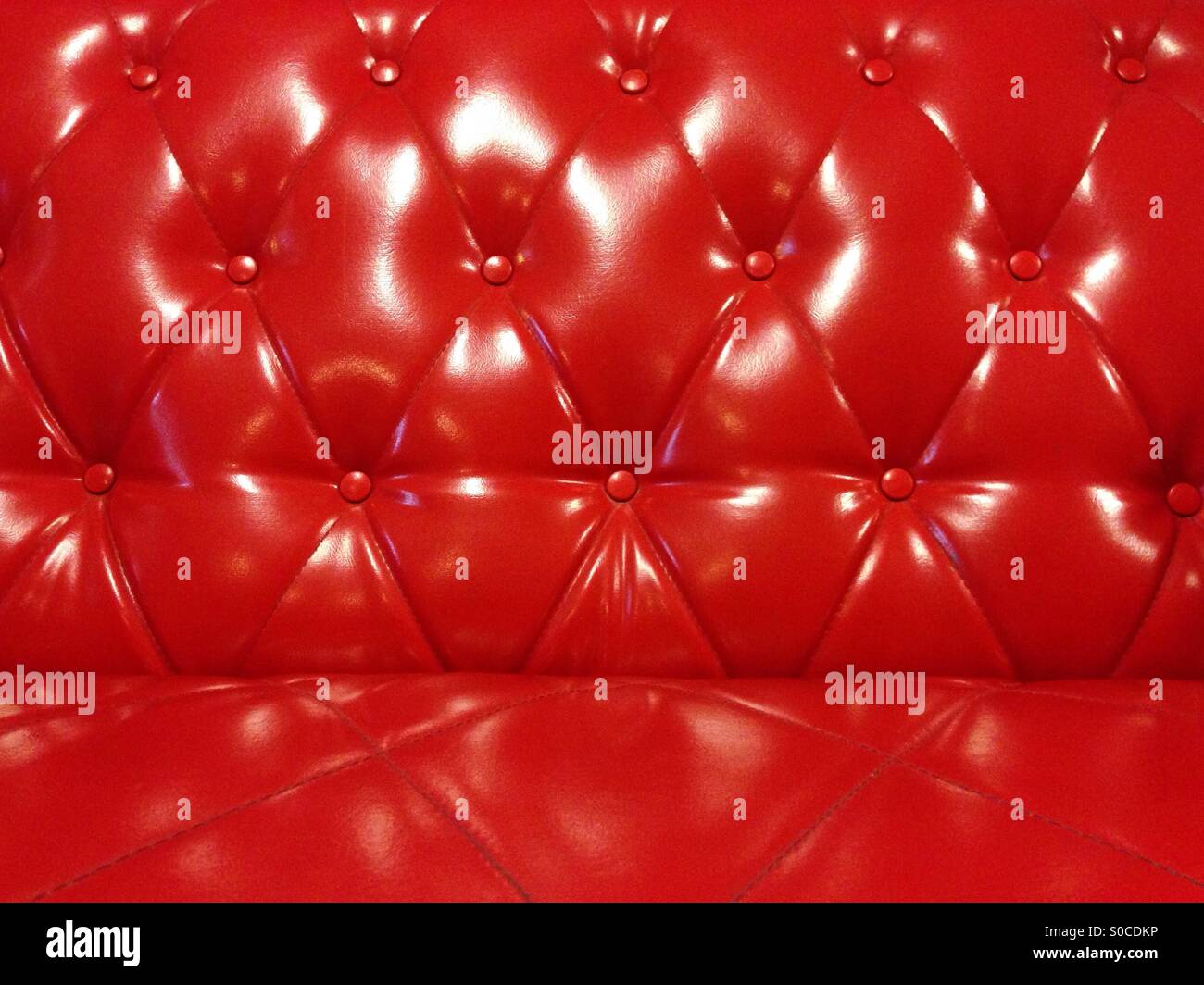 Glossy red leather sofa background Stock Photo