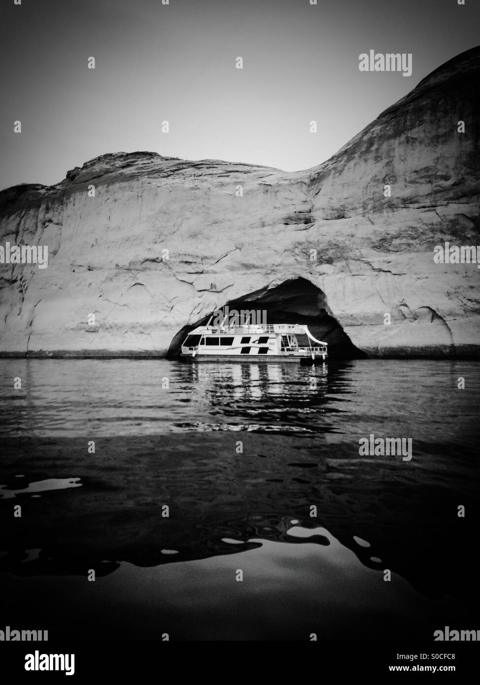 House boat on Lake Powell framed by natural cave Stock Photo Alamy