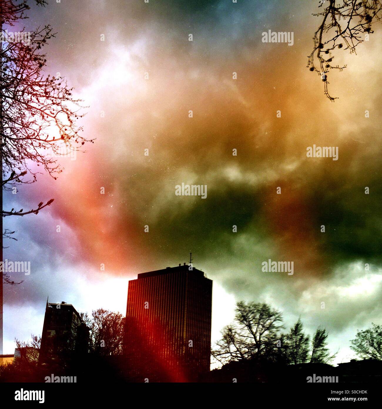 Sun breaking through the clouds over a city - Smartphone Captured Stock Image