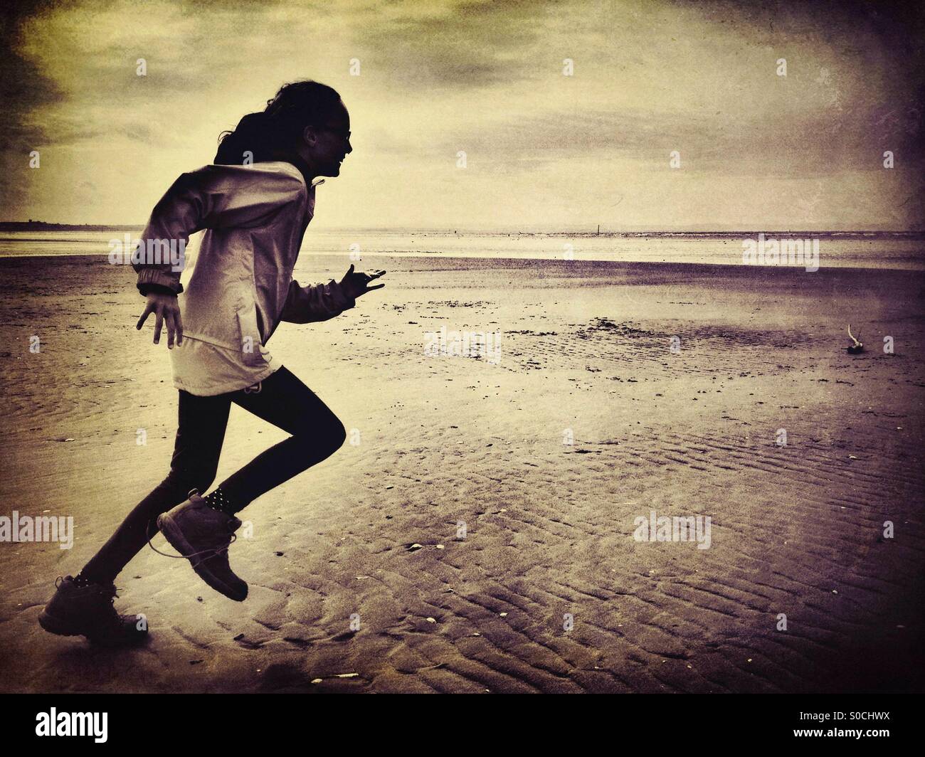 Young girl running on beach Stock Photo - Alamy