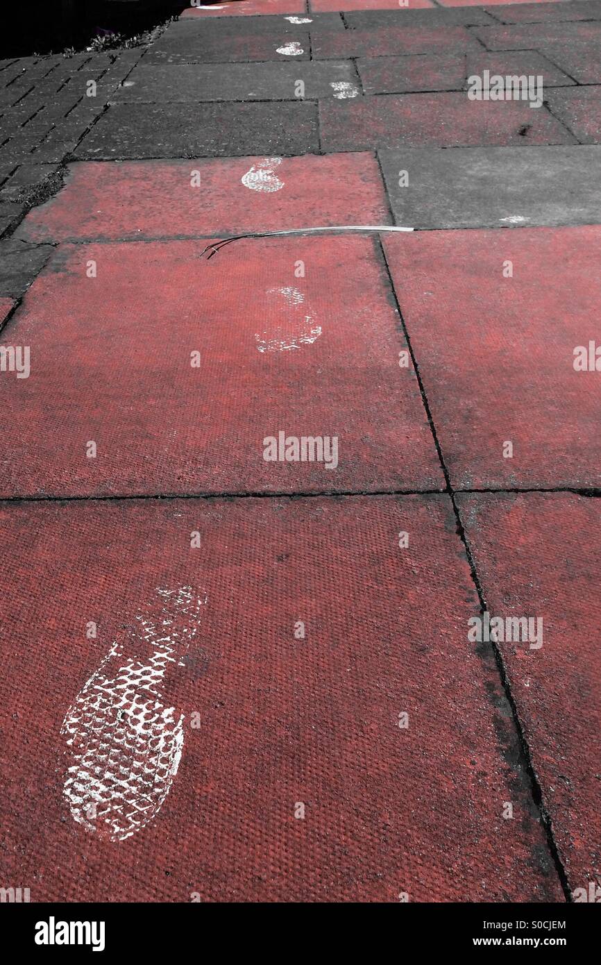 Footprints from shoes that have stepped in white paint. Stock Photo