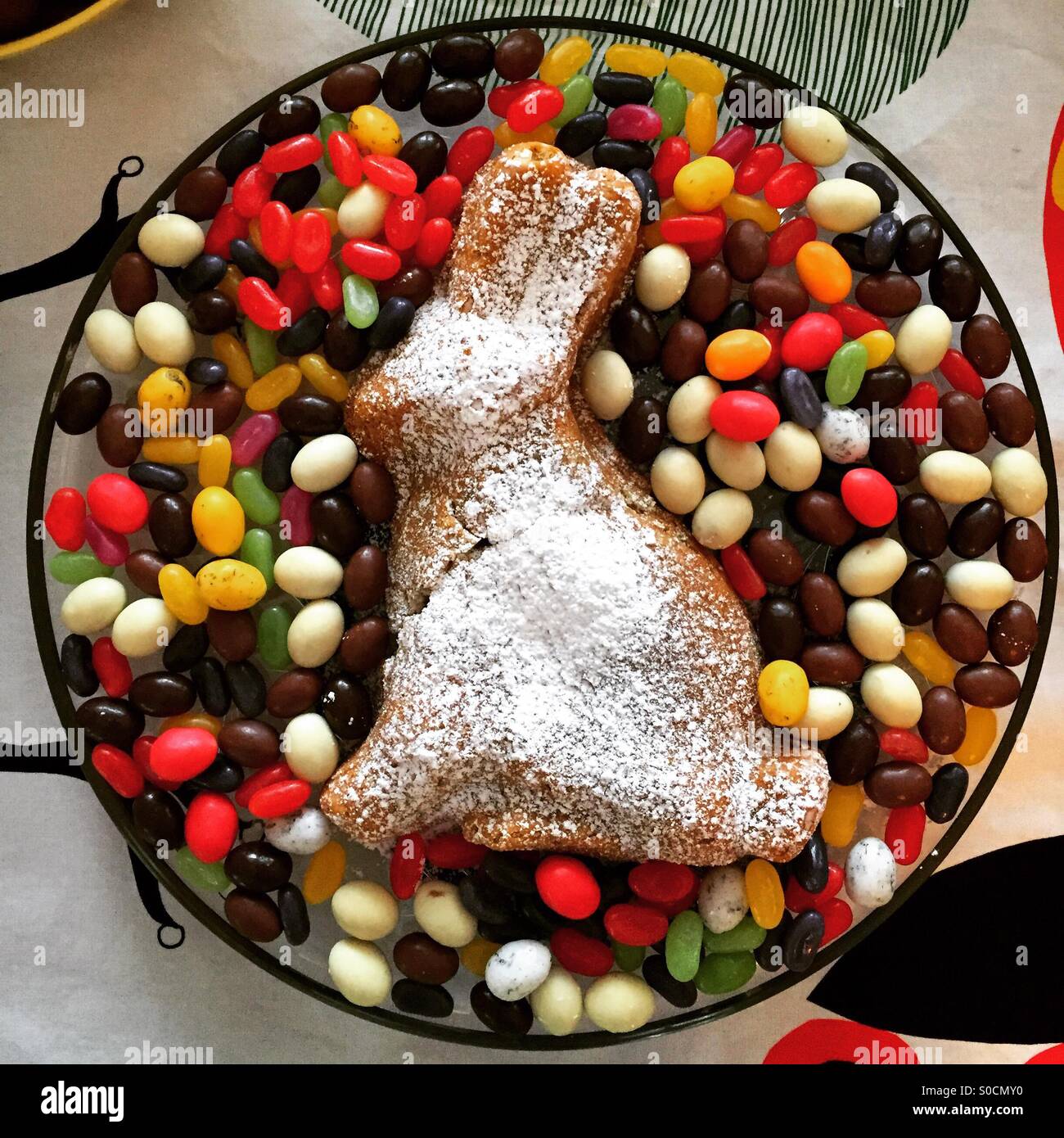A home made Easter cake in the shape of a bunny rabbit floating on a sea of candy sweets. Homemade cooking - Smartphone Captured Stock Image