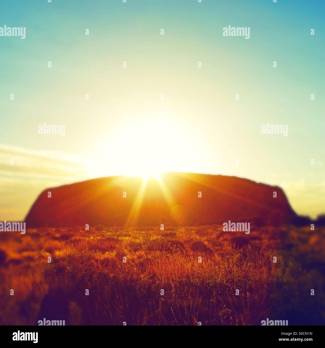 Sun breaking over Uluru (Ayers Rock) in Australia - Smartphone Captured Stock Image