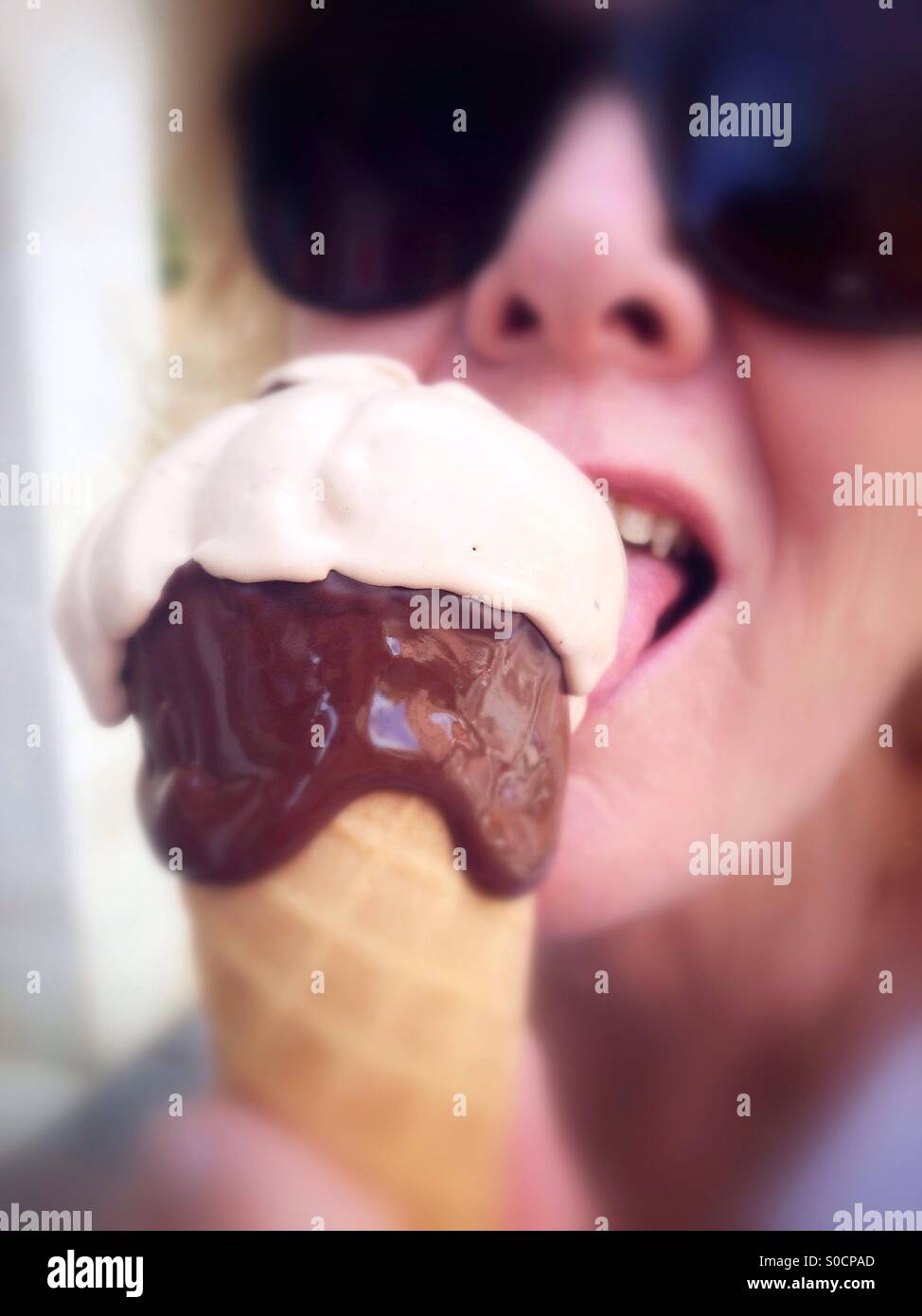 Woman in sunglasses eating cone ice cream - Smartphone Captured Stock Image