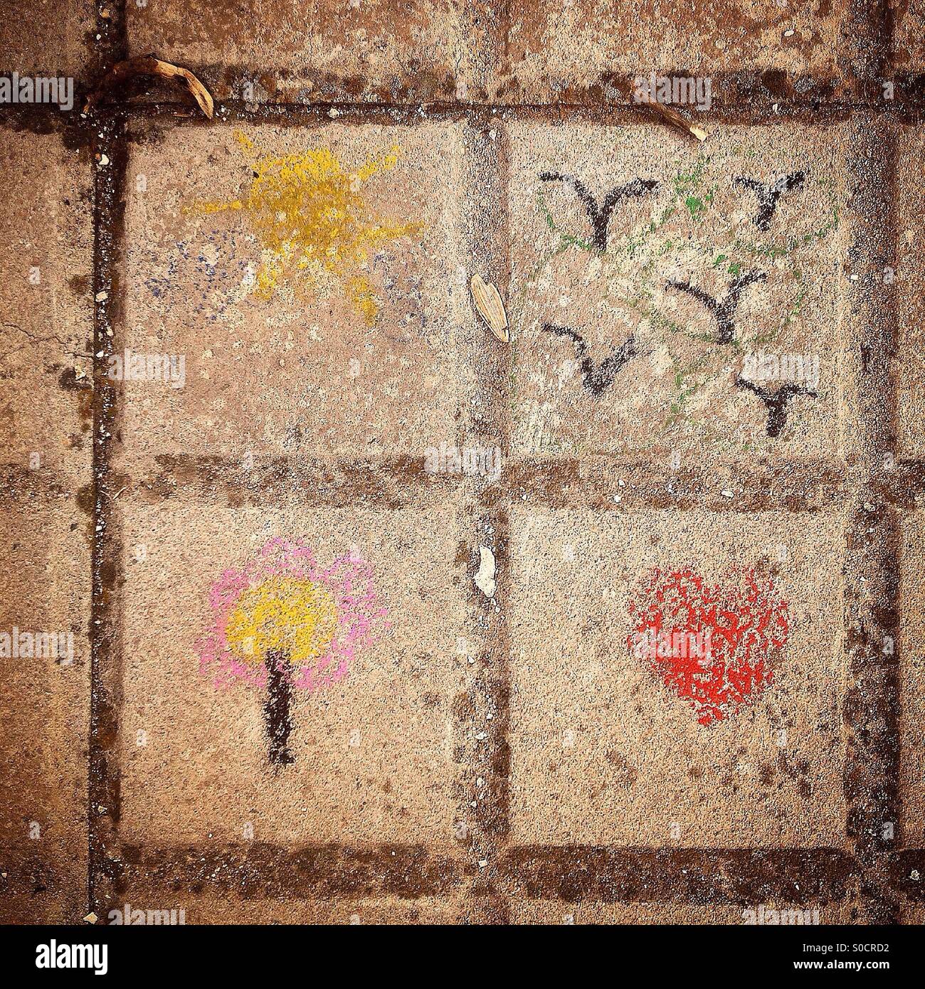 Children paintings of a tree, a heart, birds in a forest and a sun in a street of Santa Olalla de Cala, Huelva, Spain - Smartphone Captured Stock Image