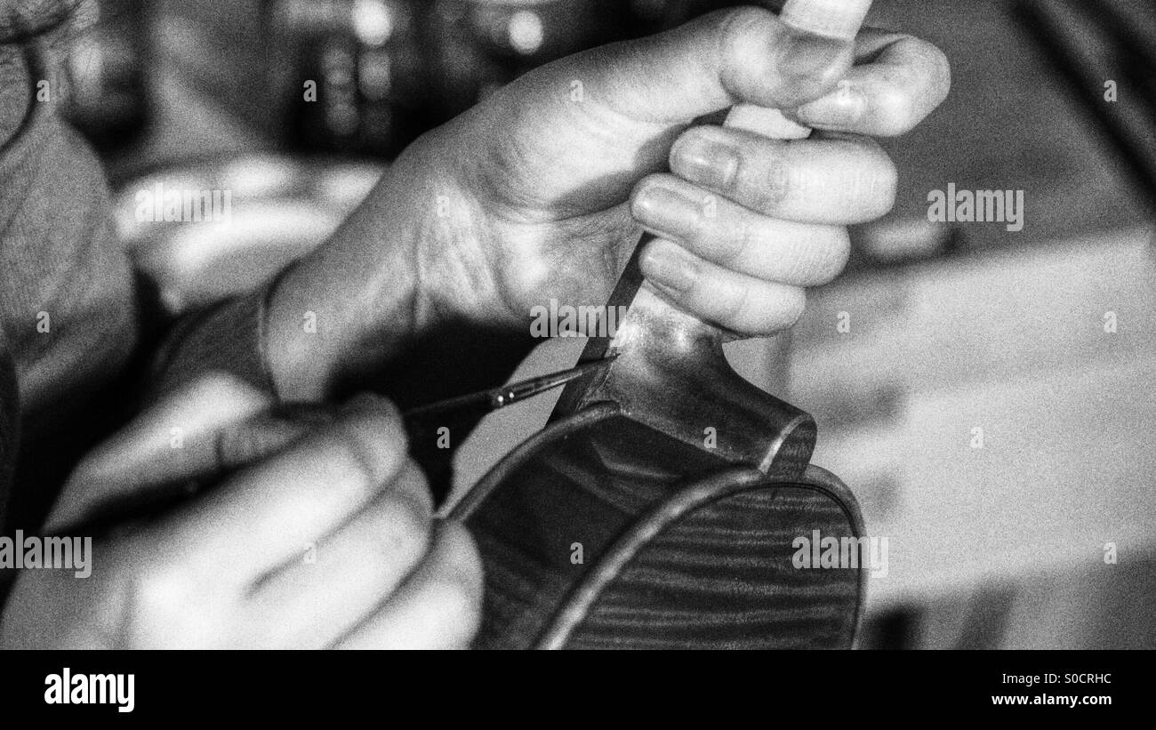 Violinmaker varnishing violin - Smartphone Captured Stock Image