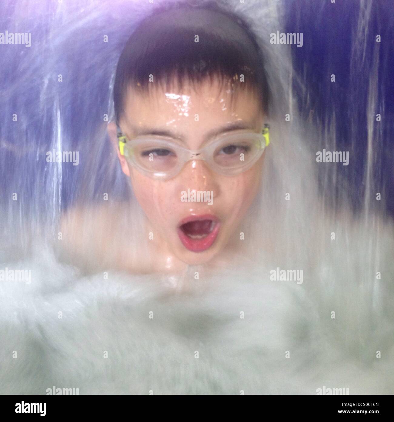 Boy in swimming pool and waterfall Stock Photo