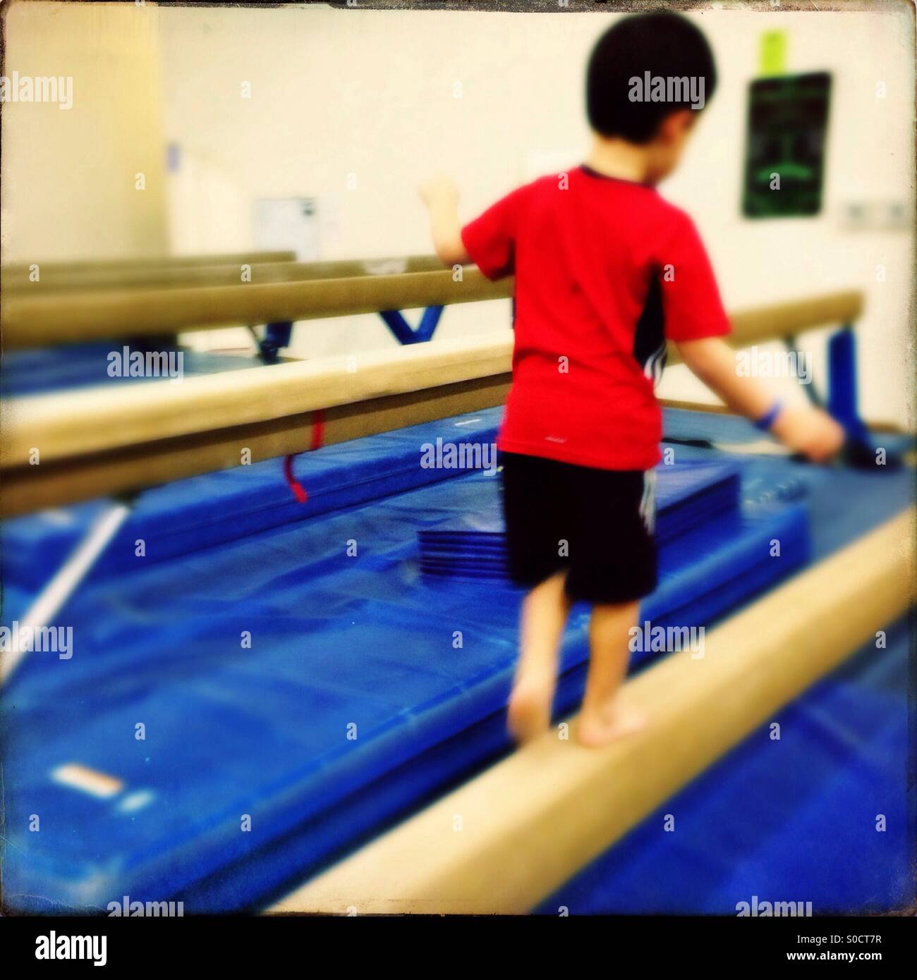 Boy on gymnastics balance beam Stock Photo