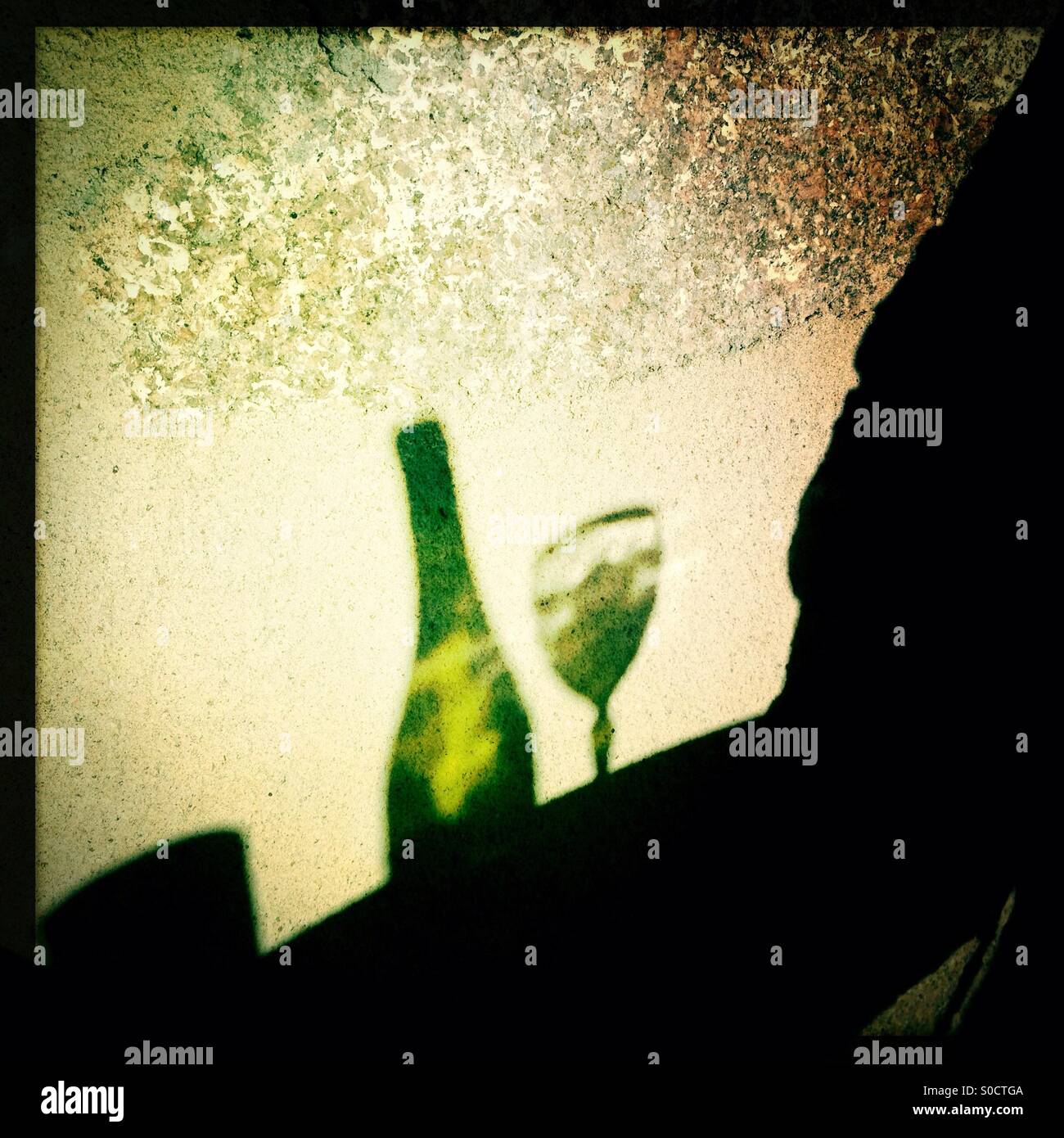 Sun shining reflection of glass and bottle of white wine onto wall - Smartphone Captured Stock Image Sun shining reflection of glass and bottle of white wine onto wall - Smartphone Captured Stock Image