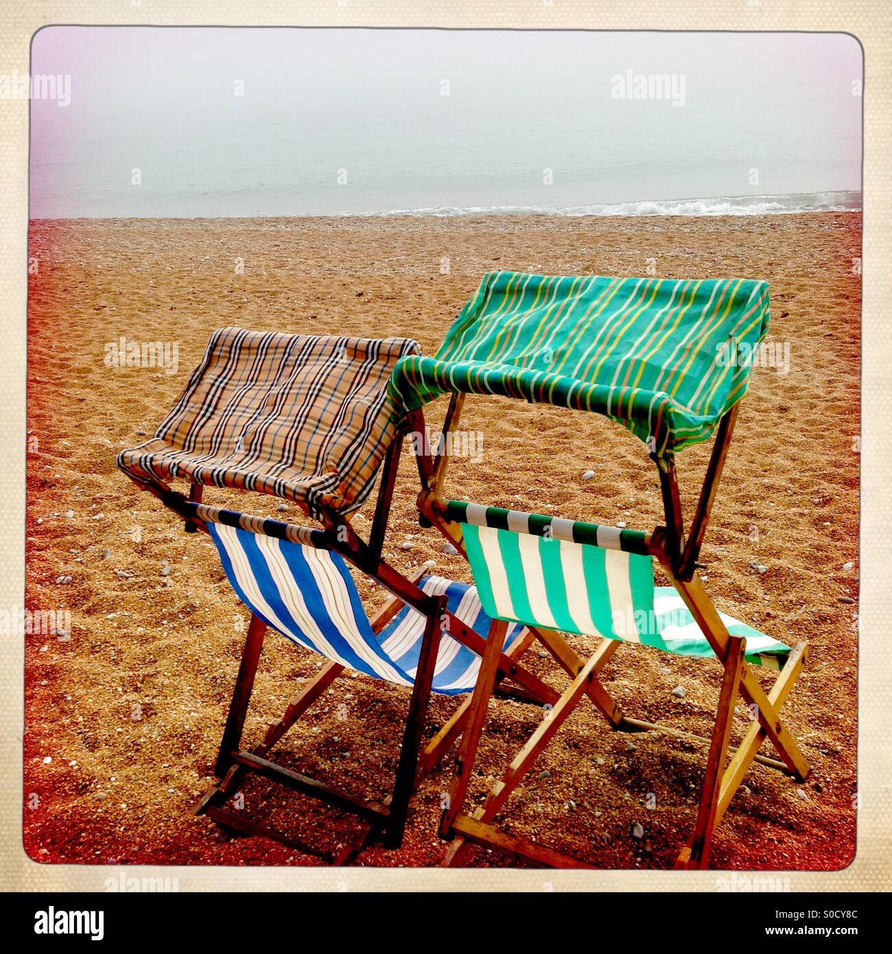 Two empty deckchairs on an empty beach Stock Photo