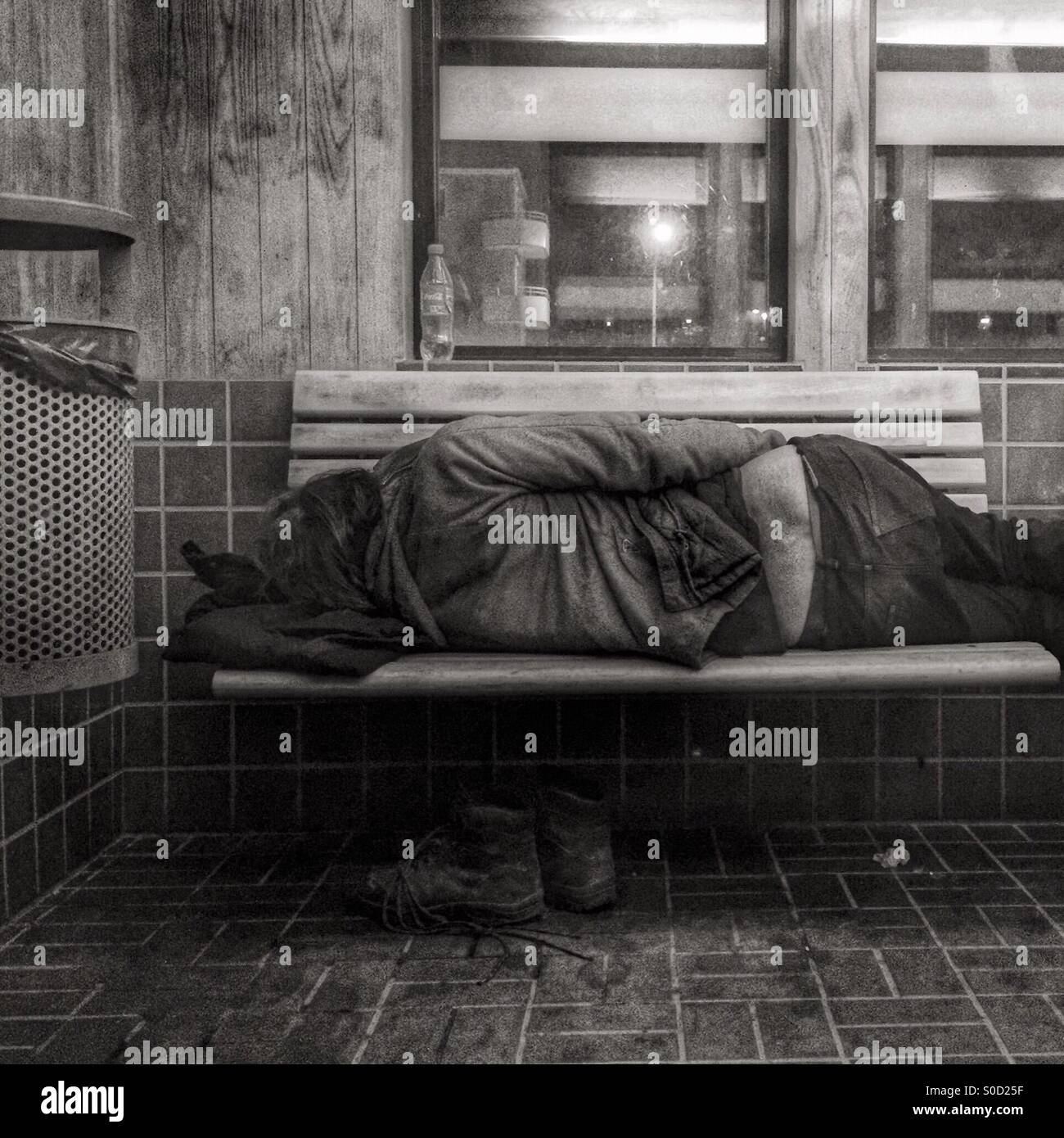 Homeless man sleeping on a bench Stock Photo