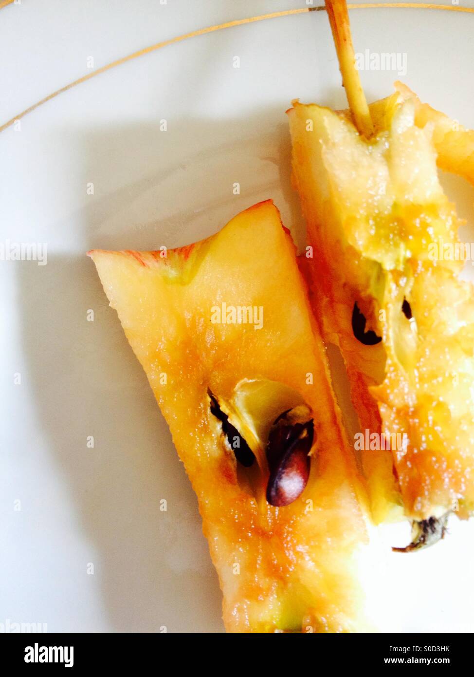 Two discarded apple cores on a white plate - Smartphone Captured Stock Image