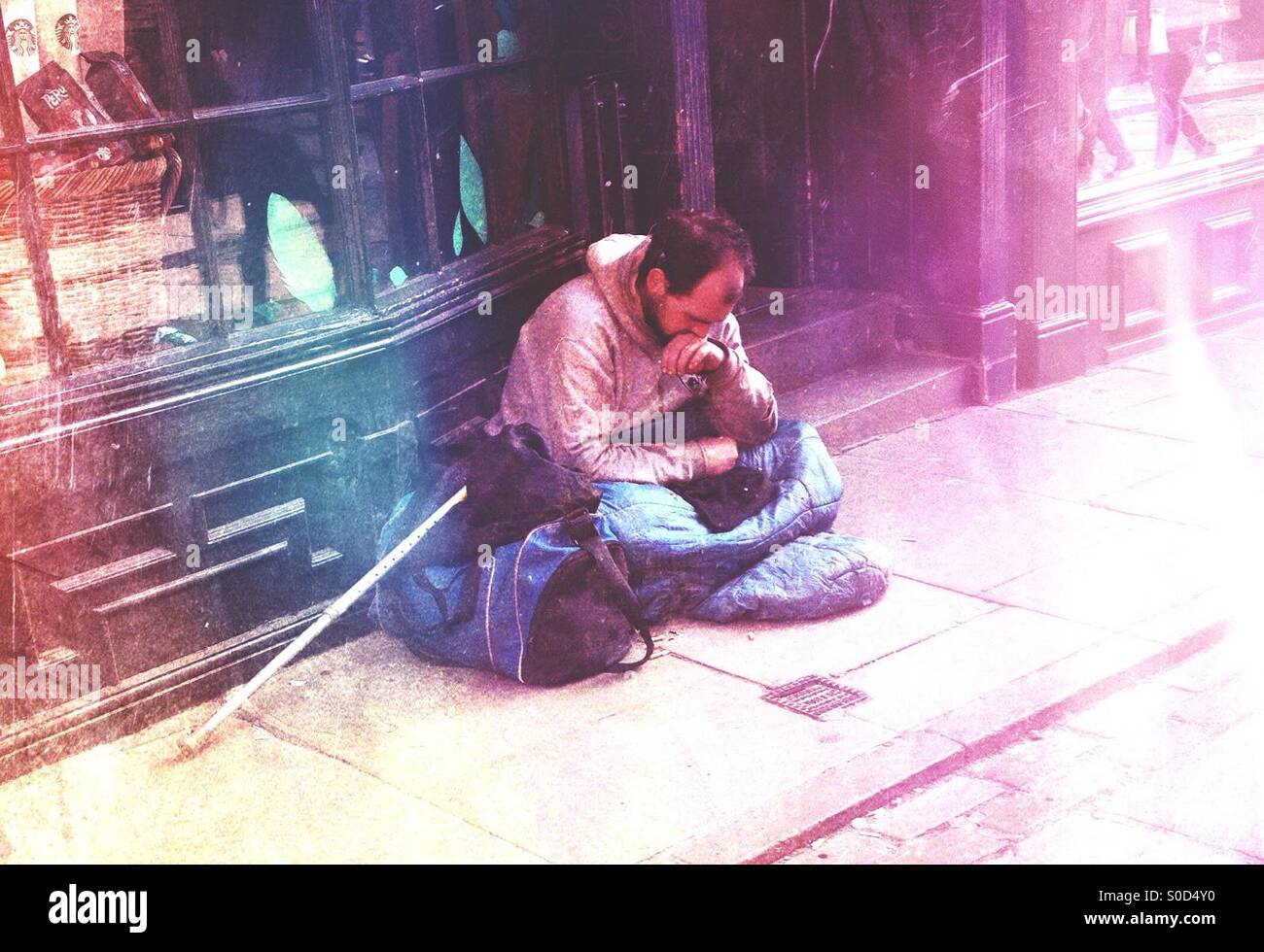 Homeless man near a shop doorway Stock Photo